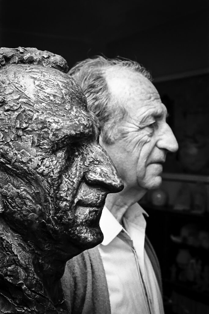 נחום גוטמן בסטודיו שלו לצד פסל ראש שלו שפוסל בידי חנה אורולוף - הירש רחל