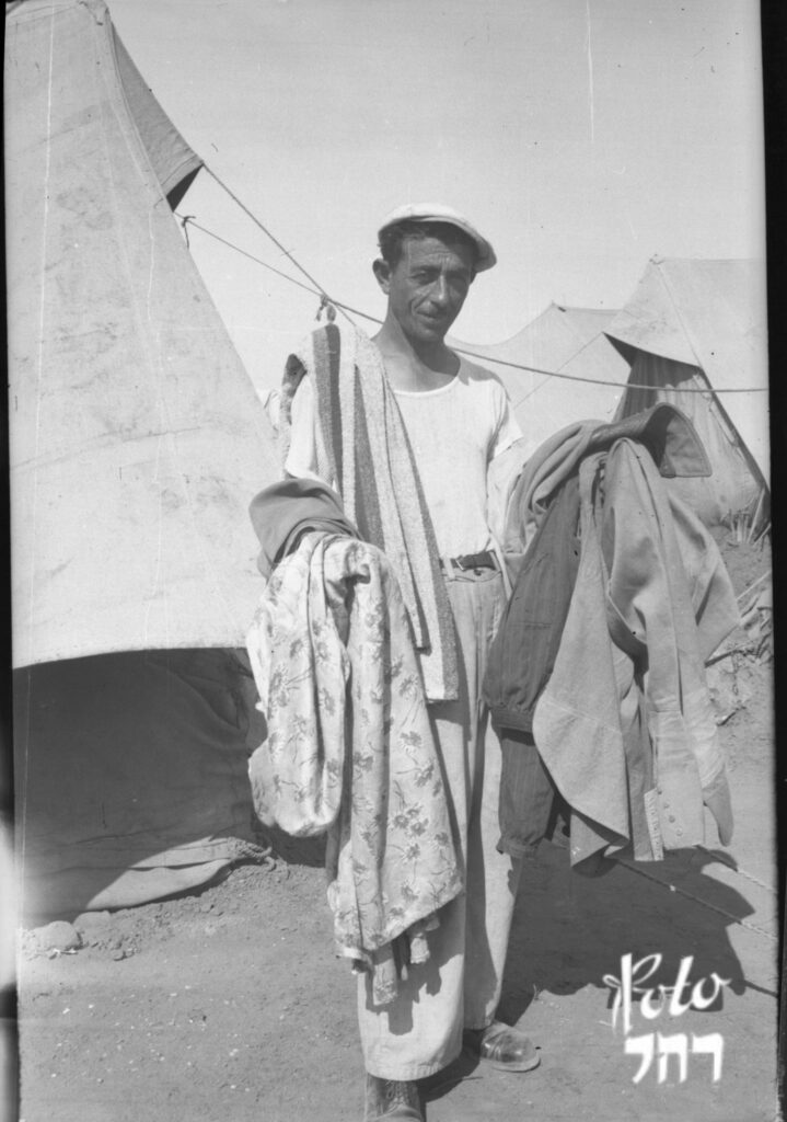 עציר במחנה סוחב ערימת בגדים - פישר רחל