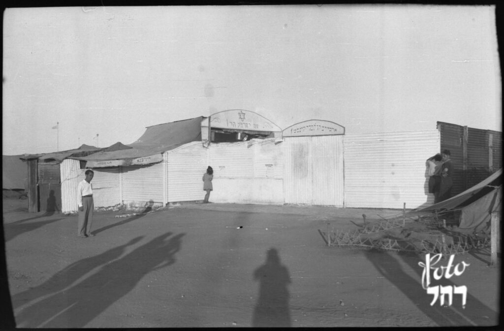 על השלט מימין, ביידיש "ארכיון. תרבות. אמנות" - פישר רחל