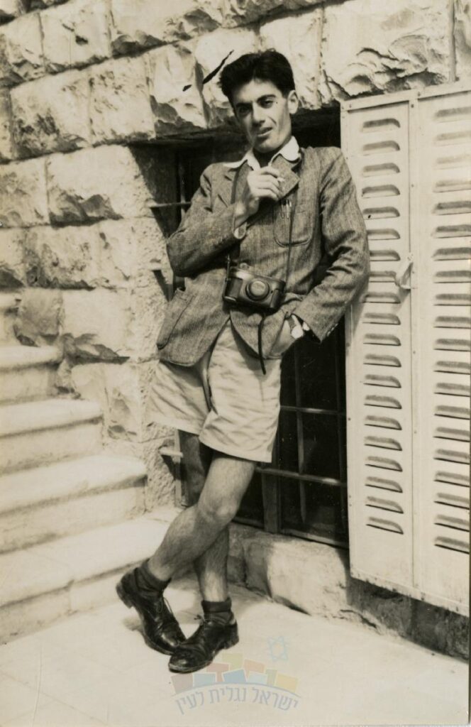 ישראל ספקטור עם מצלמתו נשען על קיר בניין, ירושלים, שנות ה-30, באדיבות באדיבות ישראל נגלית לעין, יד יצחק בן צבי. 