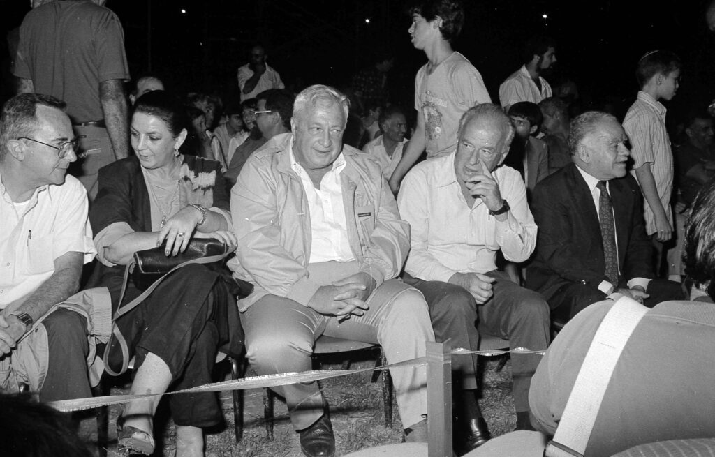 מימין: יצחק שמיר, יצחק רבין, אריק שרון, לילי שרון ומשה ארנס בכנס הצנחנים, פארק הירקון - הוכמן יוסף